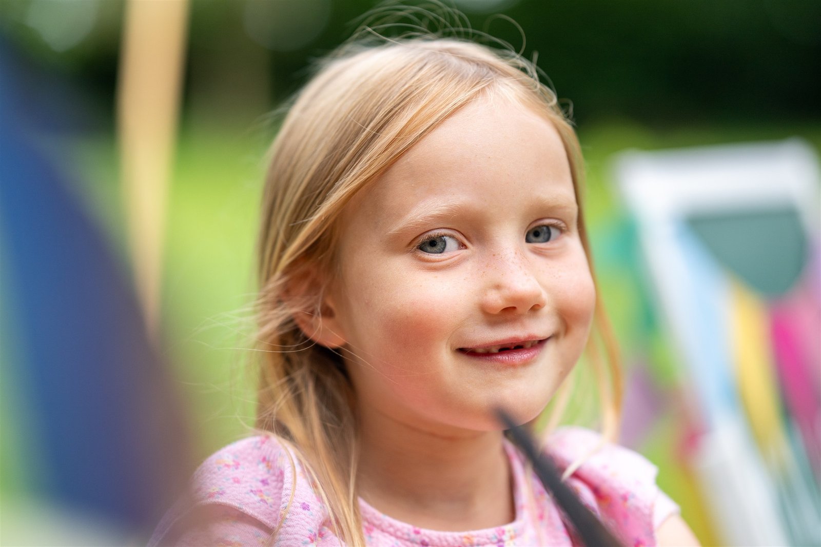 Fröhliches Schulkind bei einem natürlichen Fototermin im Grünen